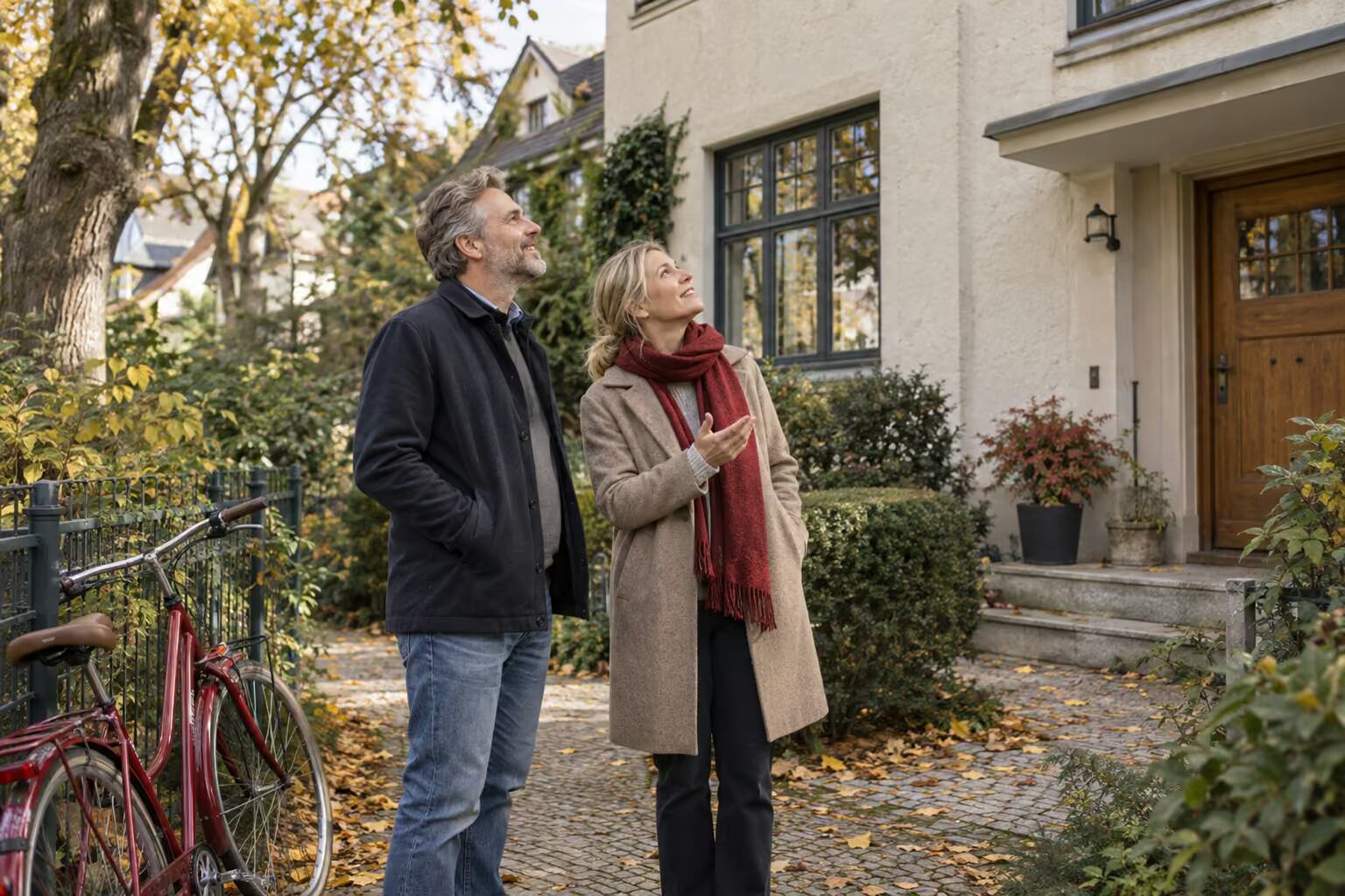 Ein Paar steht vor seinem älteren Haus in Berlin und betrachtet die Fassade